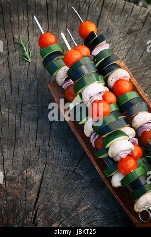 Frühling Garten Grill. Gemüse Kebab mit Cherry-Tomaten, Zucchini, Auberginen auf hölzernen Hintergrund Stockfoto