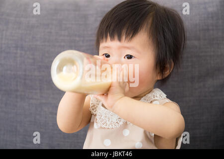 Asiatische Mädchen mit Milchflasche füttern Stockfoto