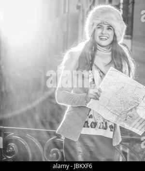 Venedig. Abseits der ausgetretenen Pfade. lächelnde trendige touristischen Frau in Pelzmütze in Venedig im Winter mit Karte Stockfoto