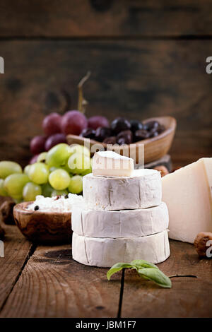Käse-Vielfalt. Essen-Hintergrund.  Frische Zutaten auf Holz Stockfoto