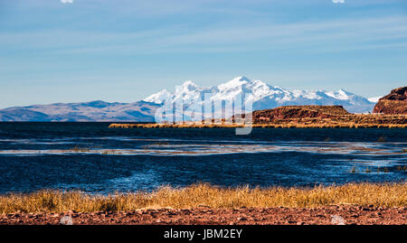 Titicaca-See von der bolivianischen Seite. Der See befindet sich am nördlichen Ende des Altiplano Bassins abflusslose hoch in den Anden an der Grenze zwischen Peru und Bolivien. Der westliche Teil des Sees liegt in der Puno Region, Peru, und die östliche Seite befindet sich in der bolivianischen La Paz Department.The See aus zwei fast separaten Teileinzugsgebieten, die durch die Meerenge besteht von Tiquina, die 800 m (2.620 ft verbunden sind) über an der schmalsten Stelle ist. Die größeren Teileinzugsgebiet hat Lago Grande (auch genannt Lago Chucuito) eine mittlere Tiefe von 135 m (443 ft) und eine maximale Tiefe von 284 m (932 ft). Je kleiner Stockfoto