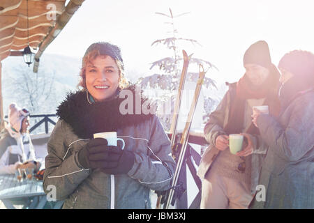 Porträt lächelnden Fahrerin Kaffeetrinken auf Kabinendeck mit Freunden Après-Ski Stockfoto