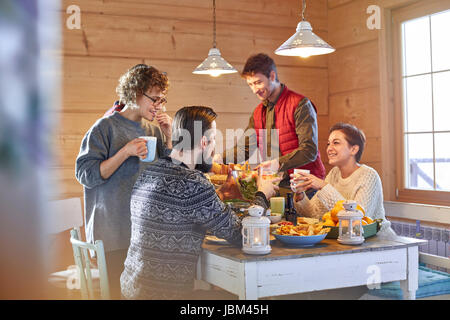 Freunde, Essen und reden an Kabine Tisch Stockfoto