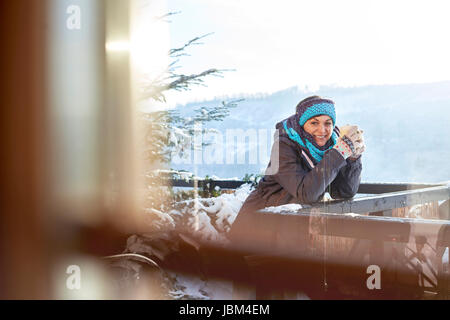 Porträt lächelnden Fahrerin trinken heißen Kakao auf sonnigen Kabine Balkon Stockfoto