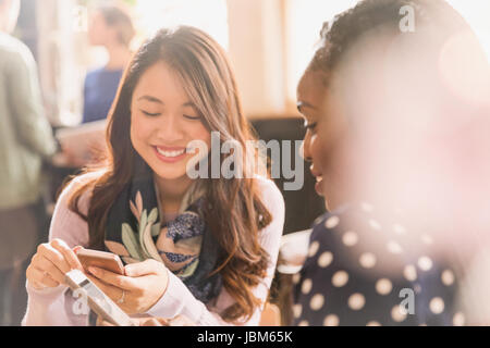 Freundinnen-SMS mit dem Handy im café Stockfoto