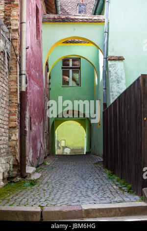 Sighisoara, Rumänien - 23. Juni 2013: Alte Stein gepflasterte Straße mit Bögen von Sighisoara/Schäßburg Festung, Siebenbürgen, Rumänien Stockfoto