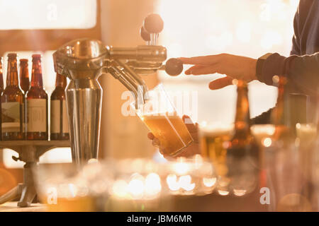 Bier vom Zapfhahn Barkeeper hinter Bar Stockfoto