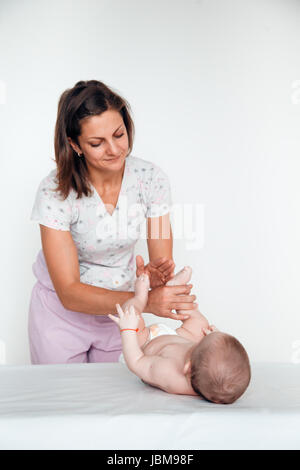 Frau Doktor macht dem Baby eine sanfte Massage. Die Kindermassage. Stockfoto