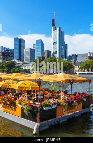 Schwimmendes Restaurant Bootshaus am Ufer des Mains mit der Skyline von Finanzviertel hinter Frankfurt am Main, Hessen, Deutschland Stockfoto