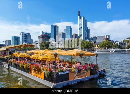 Schwimmendes Restaurant Bootshaus am Ufer des Mains mit der Skyline des Finanzzentrums hinter Frankfurt am Main, Hessen, Deutschland Stockfoto