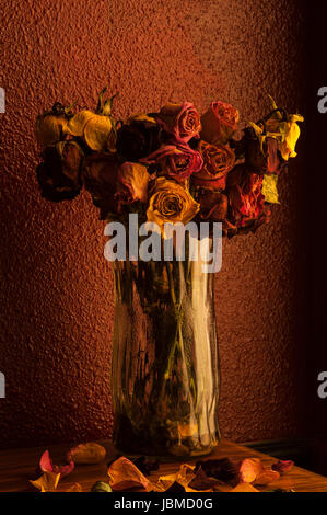 Bunte Rosen in Glasvase mit warmen Fenster Fensterlicht welke Stockfoto