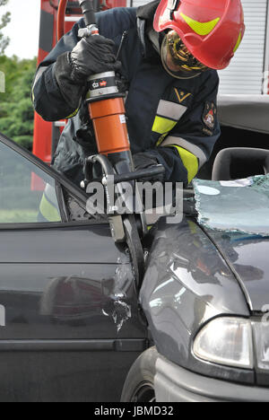 Ein Feuerwehrmann mit hydraulischen schneiden Scheren während Fahrzeug Bergung Übung Stockfoto