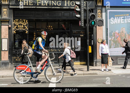 Eine behelmte Radfahrer reiten Boris Bike auf der London Street. Stockfoto