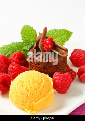 Mini-Schokoladen-Kuchen mit frischen Himbeeren und Kugel Eis serviert Stockfoto