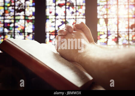 Hände gefaltet im Gebet auf eine Bibel in kirchlichen Konzept für glauben, Spiritualität und religion Stockfoto