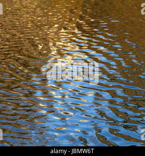 Verwenden Sie Gold und blau Abendlicht spiegelt auf Wellen auf der Wasseroberfläche, als Hintergrund. Stockfoto