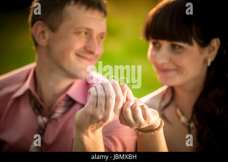 Closeup Portrait mit selektiven Fokus auf Besitz lächelnde Paar Trauringe Stockfoto
