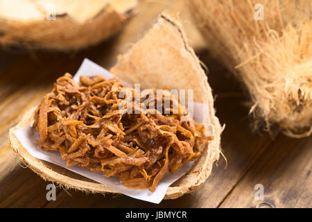 Peruanische Cocada, traditionelle Kokos Dessert in der Regel auf der Straße verkauft gemacht Kokosraspeln und brauner Zucker, wodurch die dunkle Farbe des süßen (selektiven Fokus, Fokus ein Drittel Ino die Cocada) Stockfoto