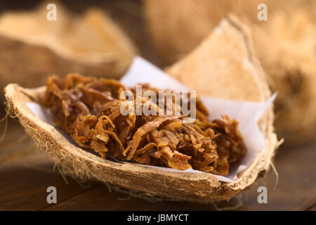 Peruanische Cocada, traditionelle Kokos Dessert in der Regel auf der Straße verkauft gemacht Kokosraspeln und brauner Zucker, wodurch die dunkle Farbe des süßen (selektiven Fokus, Fokus auf der Vorderseite der Cocada) Stockfoto
