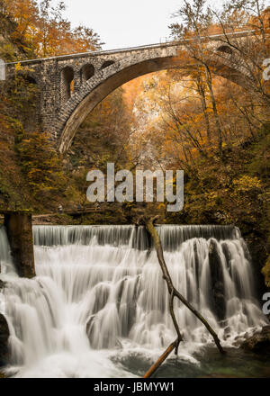 Eine Eisenbahnbrücke in der Viintgar Schlucht, Slowenien mit Wasserfall Stockfoto