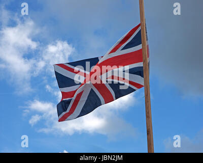 Anschluß-Markierungsfahne (oder Union Jack) die Flagge von Großbritannien fliegen bei strahlendem Sonnenschein gegen blauen Himmel mit Wolkenfetzen in Cumbria, England UK Stockfoto
