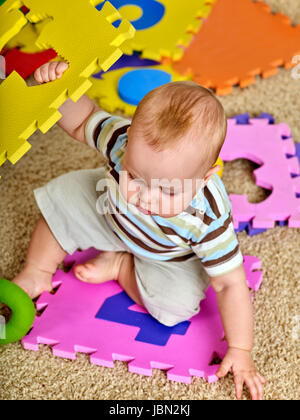 Kind-Puzzle entwickelt Kinder. Familie puzzle machen Baby. Porträt des jungen Ansicht von oben. Erdgeschoss im Kindergarten spielen. Kind lernt zu zählen und o zu studieren Stockfoto