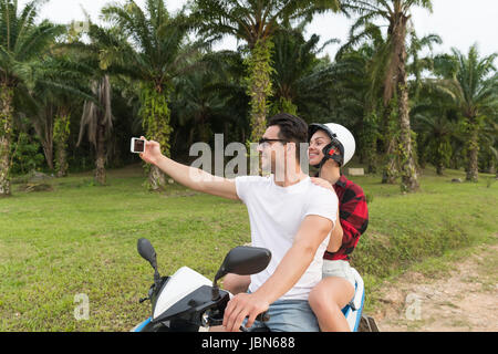 Paar auf Motorrad, Mann und Frau, die Selfie Reisen mit Fahrrad auf Tropical Forest Road Stockfoto