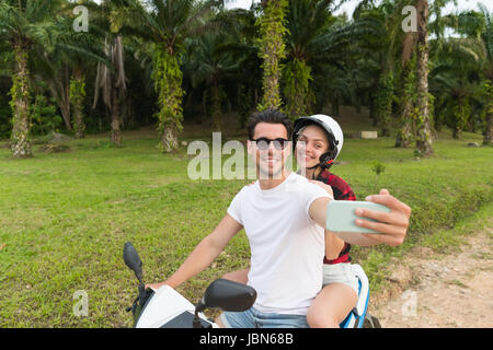 Paar auf Motorrad, Mann und Frau, die Selfie Reisen mit Fahrrad auf Tropical Forest Road Stockfoto
