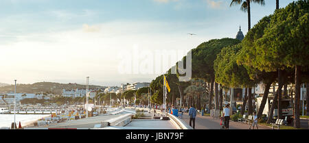 CANNES, Frankreich - 15. September 2013: Passanten am Ufer von Cannes bei Sonnenuntergang. 67. Festival de Cannes: vom 14. bis 25. Mai 2014 Stockfoto