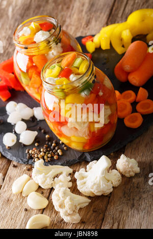 Giardiniera Salat aus eingelegtem Blumenkohl, Paprika und Karotten Nahaufnahme in Glas Gläser. Vertikal Stockfoto