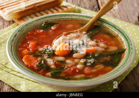 Weiße Bohnensuppe mit Tomaten, Spinat, Karotten und Parmesan-close-up auf dem Tisch. Horizontale Stockfoto