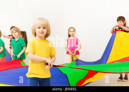 Porträt der Blondschopf Fallschirm mit seinen Freunden im Kindergarten spielen Stockfoto