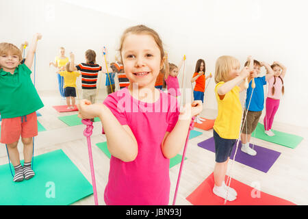 Gruppe von glücklich 5-6 Jahre alten Jungen und Mädchen, die Spaß mit springen Seile im Fitness-Studio Stockfoto