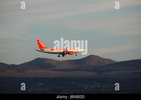 Easyjet Airbus A 319-111 Flug G-EZMK Eine endgültige Abstieg in Edinburgh Airport mit der Pentland Hills und das Dorf von ratho im Hintergrund Stockfoto