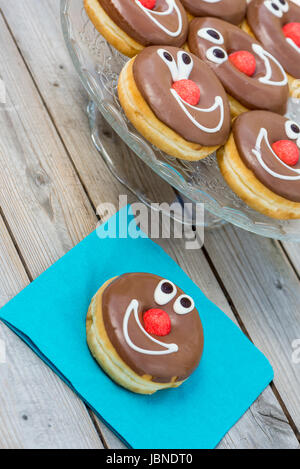 Schokolade glasierte Donuts mit lächelnden Gesichtern. geringe Schärfentiefe Stockfoto