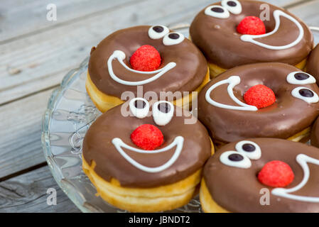 Schokolade glasierte Donuts mit lächelnden Gesichtern. geringe Schärfentiefe Stockfoto