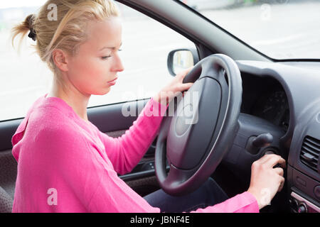 Schön leger gekleidet weibliche Autofahrer Anlassen des Motors. Stockfoto