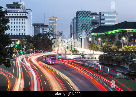 Verkehr, mit Bewegungsunschärfe, Eile entlang der Thamrin-Allee im Herzen der Innenstadt von Jakarta in Indonesien Hauptstadt in der Nacht gefangen. Stockfoto