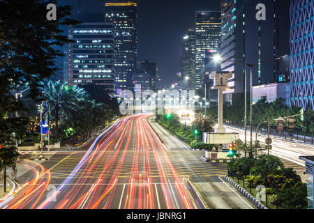 Verkehr, mit Bewegungsunschärfe, Eile entlang der Thamrin-Allee im Herzen der Innenstadt von Jakarta in Indonesien Hauptstadt in der Nacht gefangen. Stockfoto