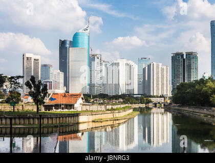 Hochhäuser, Bürogebäude und Luxushotels Türme spiegelt sich im Wasser eines Kanals in Jakarta an einem sonnigen Tag in Indonesien Hauptstadt Stockfoto