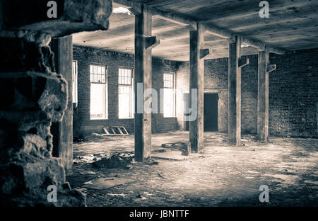 Die Aussicht aus einer alten, verlassenen Fabrik auf der Innenseite mit schönen Fensterlicht Stockfoto