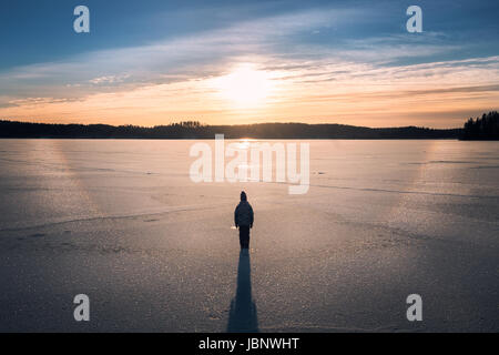 Malerische Landschaft mit stehende Kind und Sonnenaufgang am Wintermorgen in See Stockfoto