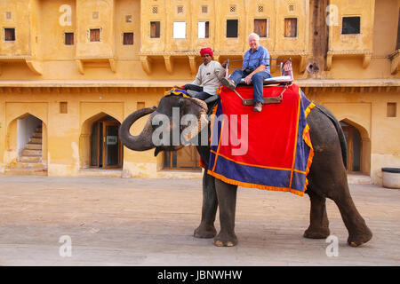 Elefant mit Touristen zu Fuß in Jaleb Chowk (Ehrenhof) in Amber Fort, Rajasthan, Indien eingerichtet. Elefantenreiten sind beliebte Touristenattraktion Stockfoto