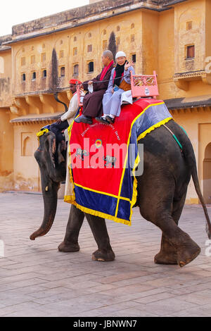 Elefant mit Touristen zu Fuß in Jaleb Chowk (Ehrenhof) in Amber Fort, Rajasthan, Indien eingerichtet. Elefantenreiten sind beliebte touristische Regionalabdeckung Stockfoto