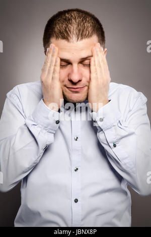 ein Mann leidet unter sehr starken Kopfschmerzen Stockfoto