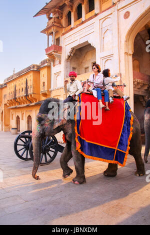 Elefant mit Touristen zu Fuß am Jaleb Chowk (Ehrenhof) in Amber Fort, Rajasthan, Indien eingerichtet. Elefantenreiten sind beliebte touristische Regionalabdeckung Stockfoto