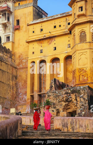 Einheimische Frauen tragen Töpfe mit Pflanzen auf ihren Köpfen zu Amber Fort, Rajasthan, Indien. Amber Fort ist die wichtigste touristische Attraktion in der Umgebung von Jaipur. Stockfoto