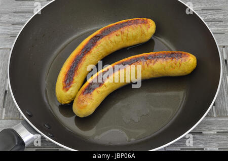 zwei gegrillte Würstchen in einer Pfanne erhitzen, Nahaufnahme, Makro, full frame Stockfoto