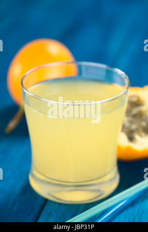 Frischer Saft gemacht süße Granadilla oder Grenadia (lat. Passiflora Ligularis) aus Glas mit Trinkhalme vor (selektiven Fokus, Fokus auf dem vorderen Rand des Glases) Stockfoto