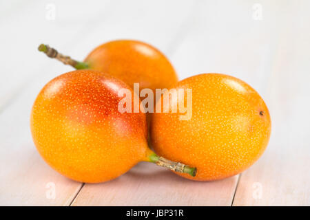 Süße Granadilla oder Grenadia (lat. Passiflora Ligularis) Obst, von denen die Samen und die umliegenden saftiges Fruchtfleisch wird gegessen oder wird verwendet, um Saft zu bereiten (selektiven Fokus, Fokus auf die Granadillas in der Front) Stockfoto